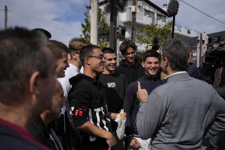 Greece's Prime Minister and New Democracy leader Kyriakos Mitsotakis, right, speaks with teenagers during his election campaign in Schimatari village about 65 kilometers (40 miles) north of Athens, Greece, Tuesday, April 25, 2023. (AP Photo/Thanassis Stavrakis)