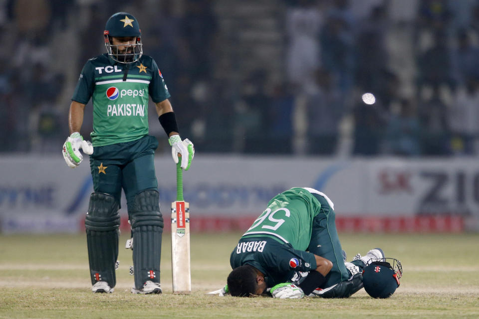 Pakistan's Babar Azam, right, kisses ground after scoring century while teammate Mohammad Rizwan watches during the first one day international cricket match between Pakistan and West Indies at the Multan Cricket Stadium, in Multan, Pakistan, Wednesday, June 8, 2022. (AP Photo/Anjum Naveed)