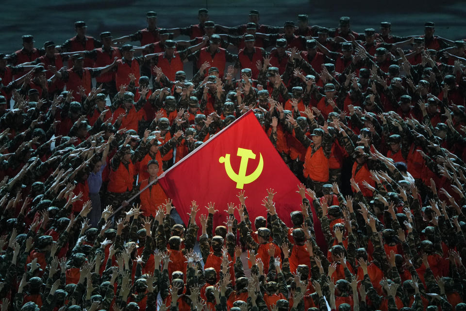 Performers in the role of rescue workers gather around a Communist Party flag during a gala show ahead of the 100th anniversary of the founding of the Chinese Communist Party in Beijing on Monday, June 28, 2021. For China's Communist Party, celebrating its 100th birthday on Thursday, July 1, is not just about glorifying its past. It's also about cementing its future and that of its leader, Chinese President Xi Jinping. (AP Photo/Ng Han Guan)