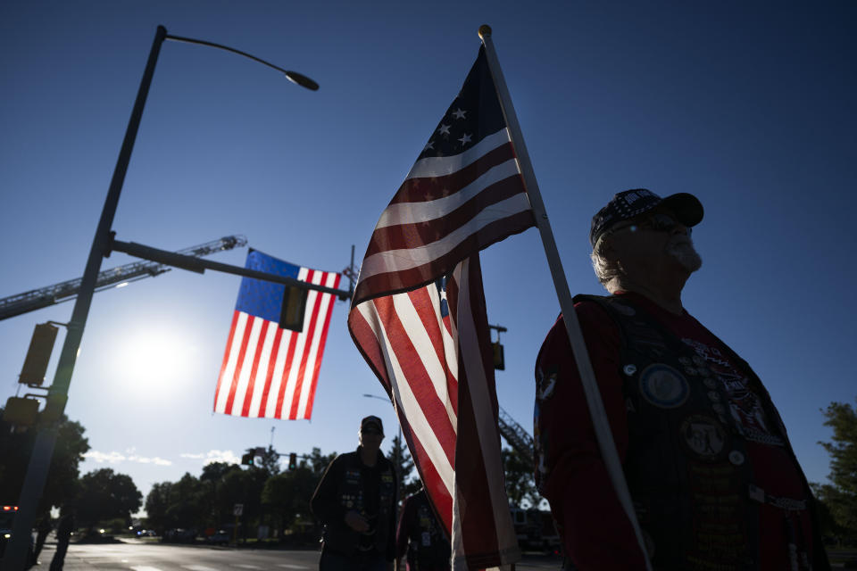 Dan Koster, with the Colorado Patriot Guard Riders, carries an American flag before lining up with other riders before the the funeral procession for fallen Arvada Police Officer Dillon Vakoff, Friday, Sept. 16, 2022, at Flatirons Community Church in Lafayette, Colo. Vakoff was fatally shot while trying to break up a large family disturbance earlier in the week, in Arvada. (Timothy Hurst/The Gazette via AP)