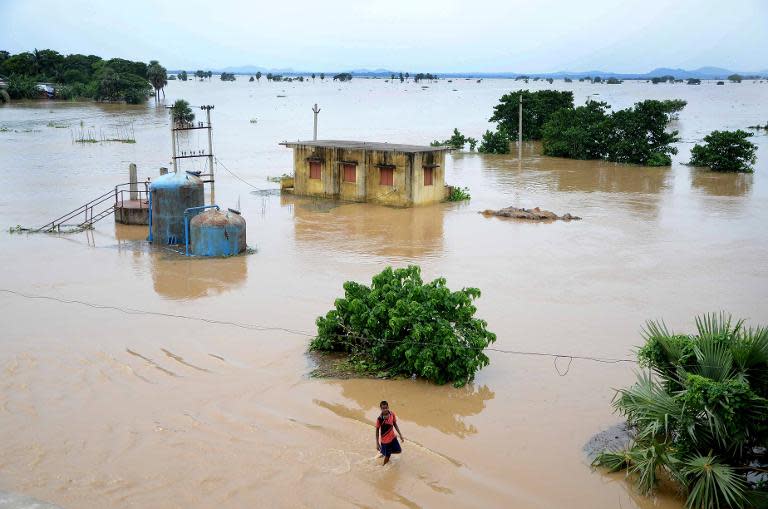 An Indian villager makes his way through floodwaters at Kakharubasta in the eastern state of Orissa, on August 7, 2014