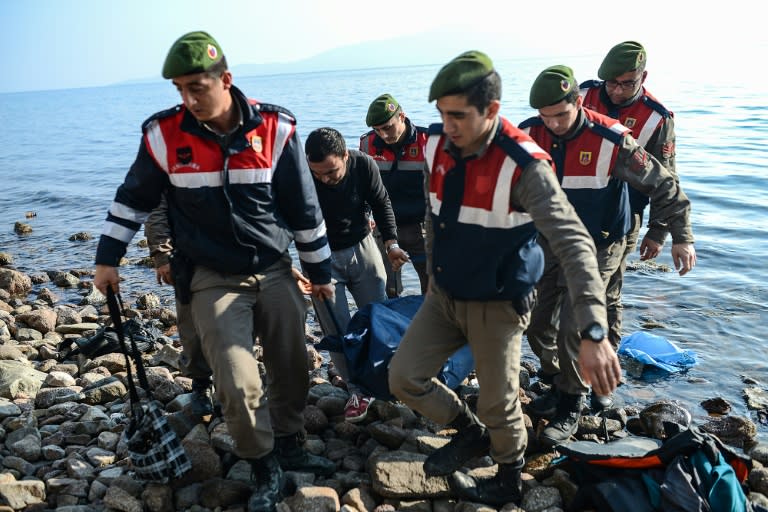 Turkish gendarmes carry the body of a migrant on a beach in Canakkale's Bademli district on January 30, 2016