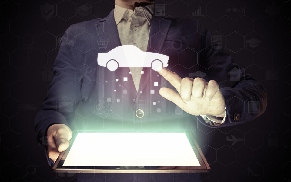 A man holding a tablet and touching a floating car icon.