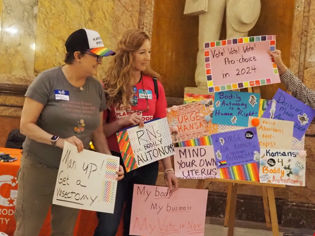Annie Stevens and fellow reproductive rights advocates hold up signs during a Monday, April 29, 2024 rally in the Statehouse. (Rachel Mipro/Kansas Reflector)