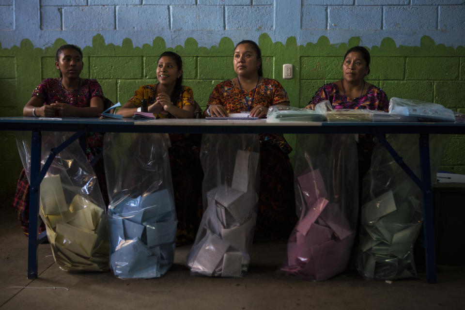 Electoral workers wait for people to cast their votes during general elections in Chinautla on the outskirts of Guatemala City, Sunday, June 16, 2019. Guatemalans are voting for their next president in elections plagued by widespread disillusion and distrust, and as thousands of their compatriots flee poverty and gang violence to seek a new life in the United States. (AP Photo/Oliver de Ros)