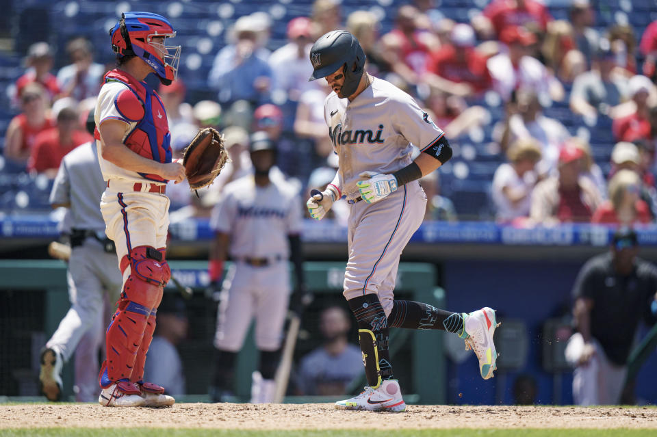 Miami Marlins' Miguel Rojas, right, comes in to score on his home run as Philadelphia Phillies catcher Garrett Stubbs, left, looks on during the fifth inning of a baseball game, Wednesday, June 15, 2022, in Philadelphia. (AP Photo/Chris Szagola)