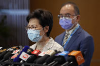 Hong Kong Chief Executive Carrie Lam, left, speaks, with Erick Tsang, Secretary for Constitutional and Mainland Affairs Bureau, behind her, during a press conference at a polling center for the election committee in Hong Kong Sunday, Sept. 19, 2021. Hong Kong's polls for an election committee that will vote for the city's leader kicked off Sunday amid heavy police presence, with chief executive Carrie Lam saying that it is "very meaningful" as it is the first election to take place following electoral reforms. (AP Photo/Vincent Yu)