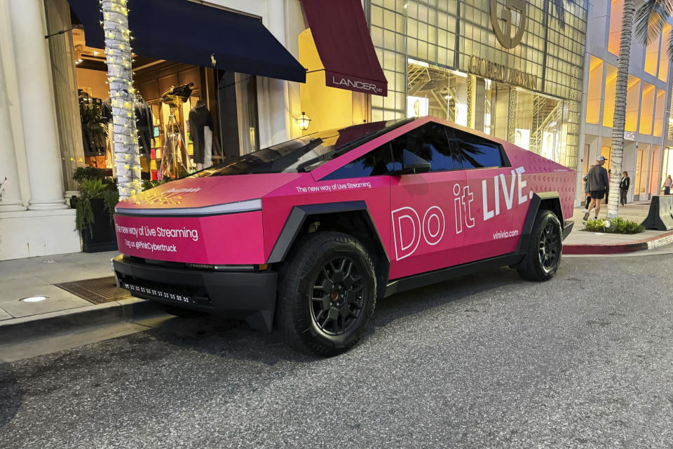 This photo provided by Edmunds shows a 2024 Tesla Cybertruck in Beverly Hills, Calif. In addition to providing an eye-popping new color, a vinyl wrap can be used for business promotional purposes. (Ryan Greger/Edmunds via AP)