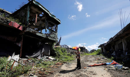 A man stands in front of his ruined house after residents were allowed to return to their homes for the first time since the battle between government troops and Islamic State militants began in May last year, in the Islamic city of Marawi, southern Philippines April 19, 2018. Picture taken April 19, 2018. REUTERS/Erik De Castro