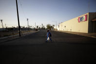Dulce Garcia carries groceries as she makes her way home to Mexico after work Wednesday, July 22, 2020, in Calexico, Calif. (AP Photo/Gregory Bull)