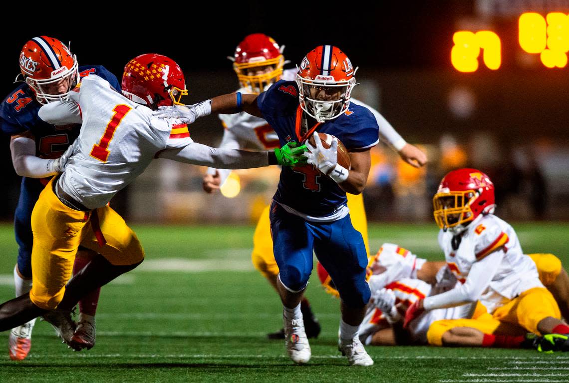 Lakes running back Ki’Marree Washington, 4, shoves Mount Tahoma safety Jukiry Bell, 1, as he runs down the field with the ball in the second quarter of a Thursday night game at Harry E. Lang Stadium in Lakewood, Wash. on Oct. 27, 2022. Lakes defeated Mount Tahoma 51-14.