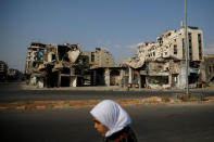 A woman walks past destroyed buildings in the government-controlled part of Homs, Syria, September 18, 2018. REUTERS/Marko Djurica