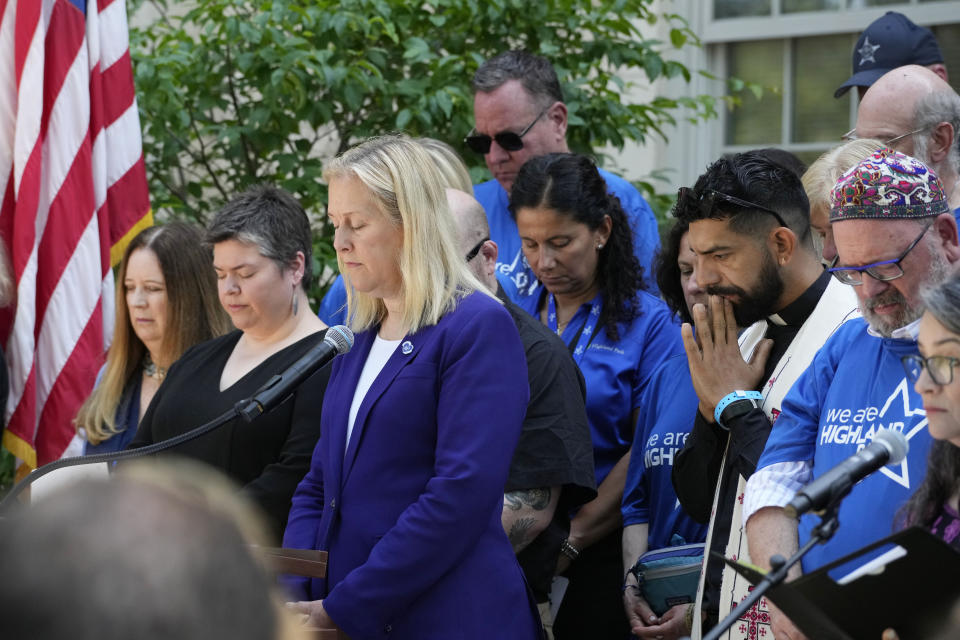 Highland Park Mayor Nancy Rotering, center, takes a moment of silence during a remembrance ceremony in Highland Park, Ill., Tuesday, July 4, 2023. One year after a shooter took seven lives at the city's annual parade, community members are planning to honor the victims and reclaim the space to move forward. (AP Photo/Nam Y. Huh)