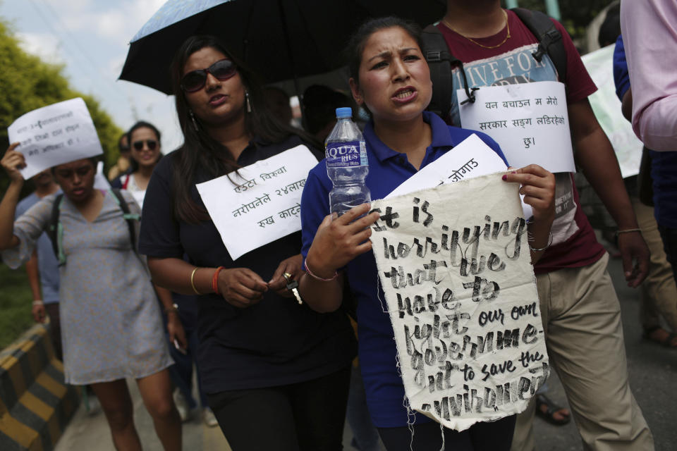 Nepalese activists shout slogans during a protest outside Civil Aviation Authority of Nepal, in Kathmandu, Monday, Aug. 19, 2019. A small group of protesters demonstrated in Nepal's capital against plans to cut down millions of trees for an international airport in the southern part of the country. (AP Photo/Niranjan Shrestha)