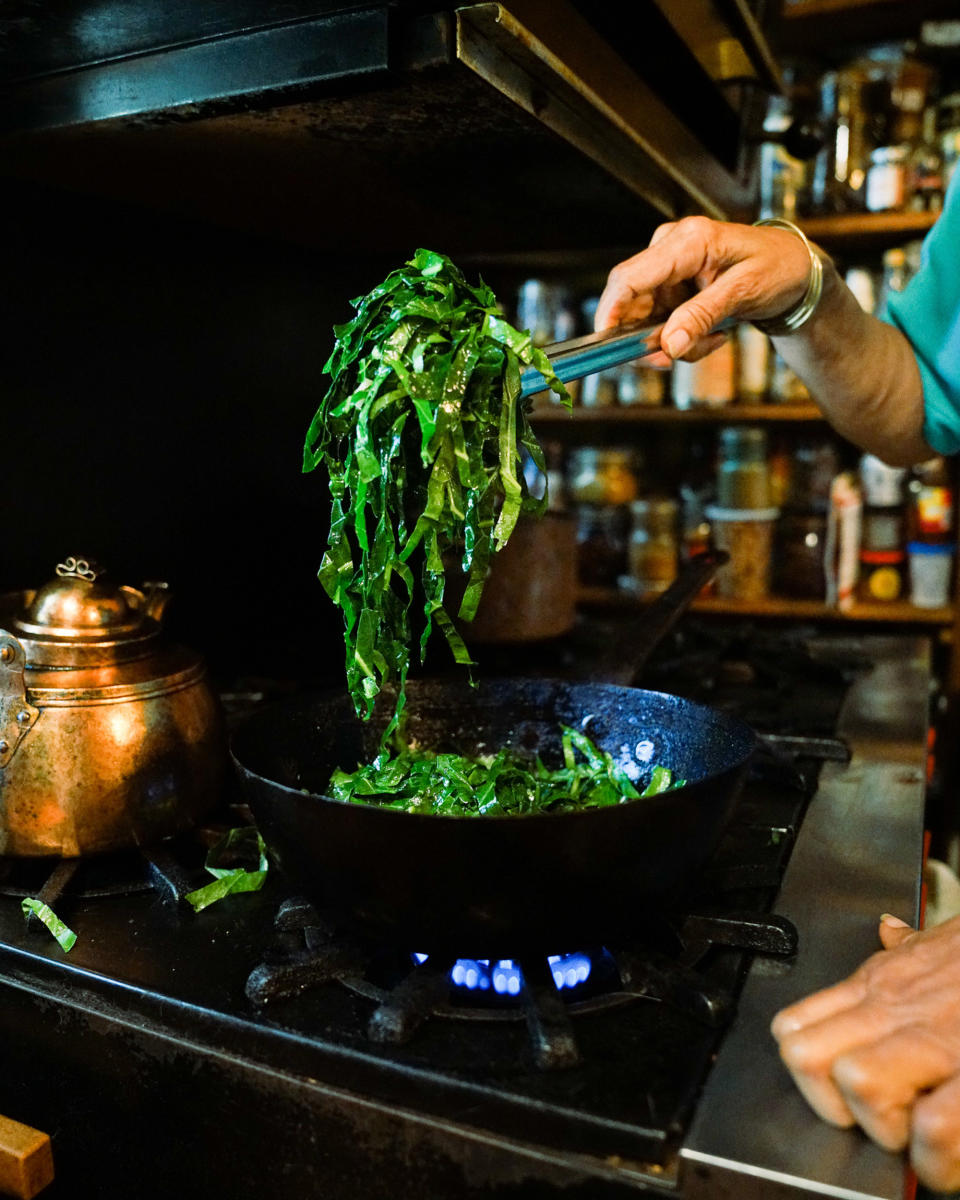 Harris cooks the collard greens, stirring often to make sure the garlic doesn't burn. (Kara Birnbaum / TODAY)