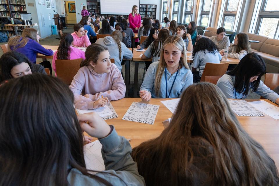 Chloe Burkards (right) of Academy of Holy Angels, talks about her family's Easter traditions while Daniella Fox (left), a student at Yeshivat Noam, listens. Middle school students from the two schools have been meeting since last fall to discuss bigotry and common ground.