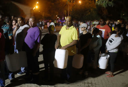 People queue to collect water from a spring in the Newlands suburb as fears over the city's water crisis grow in Cape Town, South Africa, January 25, 2018. REUTERS/Mike Hutchings