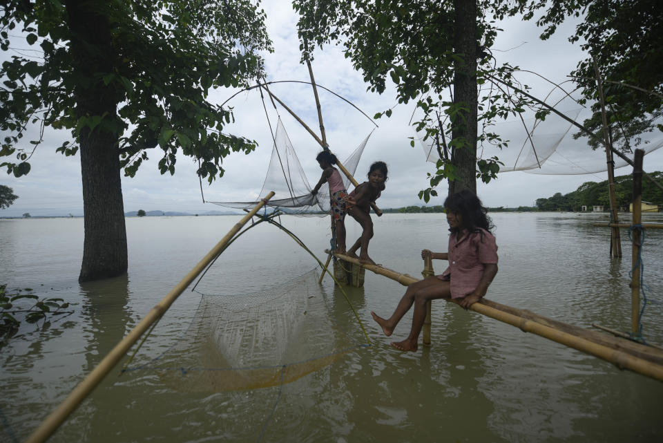 Children fishing in a flooded area in a flood effected village in Morigaon district of Assam in India on Friday, 17 July 2020. (Photo by David Talukdar/NurPhoto via Getty Images)