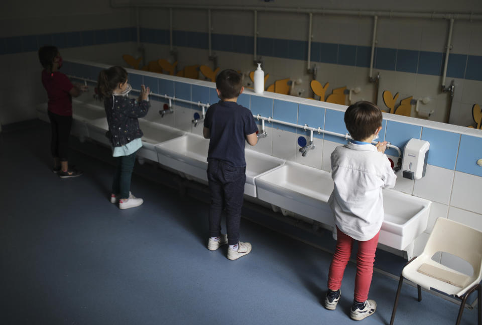 FILE - In this May 14, 2020 file photo, children wash their hands at the Saint-Tronc Castelroc primary school in Marseille, southern France. A new analysis published Monday, June 1, in the journal Lancet finds masks and social distancing help but hand washing and other measures are still needed to control the coronavirus. (AP Photo/Daniel Cole, File)