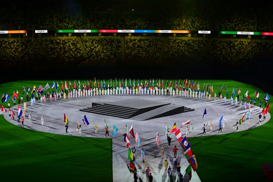 <p>Flagbearers walk onto the pitch for the closing ceremony of the Tokyo 2020 Olympic Games, at the Olympic Stadium, in Tokyo, on August 8, 2021. (Photo by Pedro PARDO / AFP) (Photo by PEDRO PARDO/AFP via Getty Images)</p> 