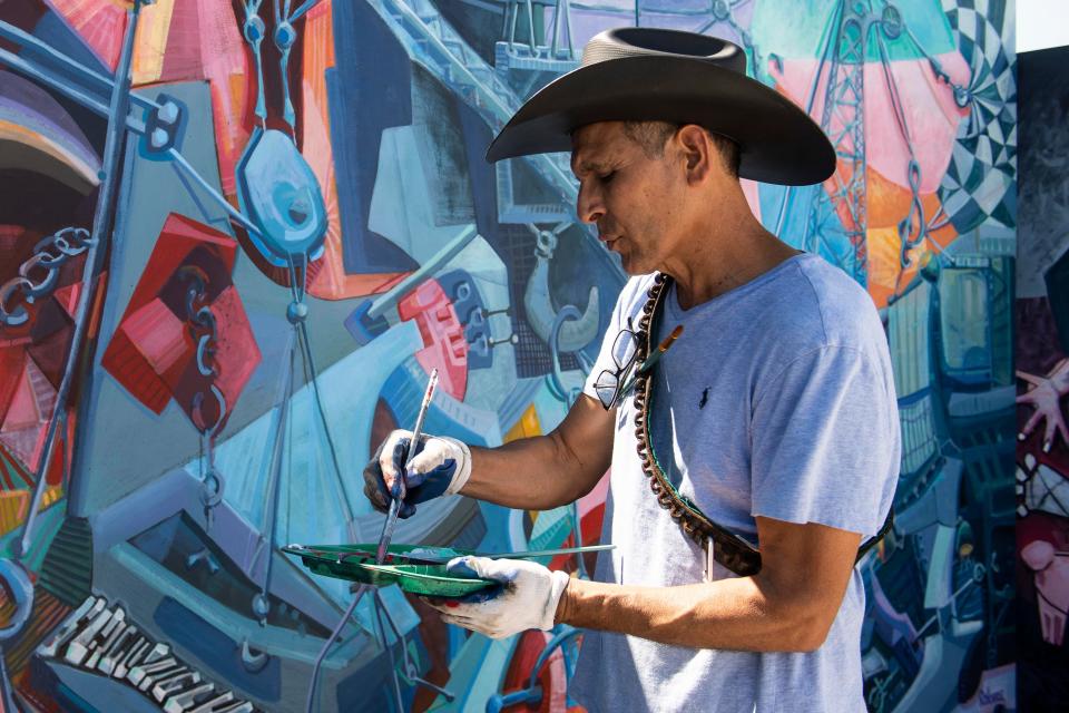 Roberto Marquez works on his mural in a parking lot of the Fort Myers, Fla. Wal-Mart on aftermath on Friday, October 7, 2022. Marquez, who arrived days after Hurricane Ian,  travels the world to paint murals that capture the emotion of the moment after tragedy or disaster. Saul Young/Knoxville News Sentinel-USA TODAY NETWORK