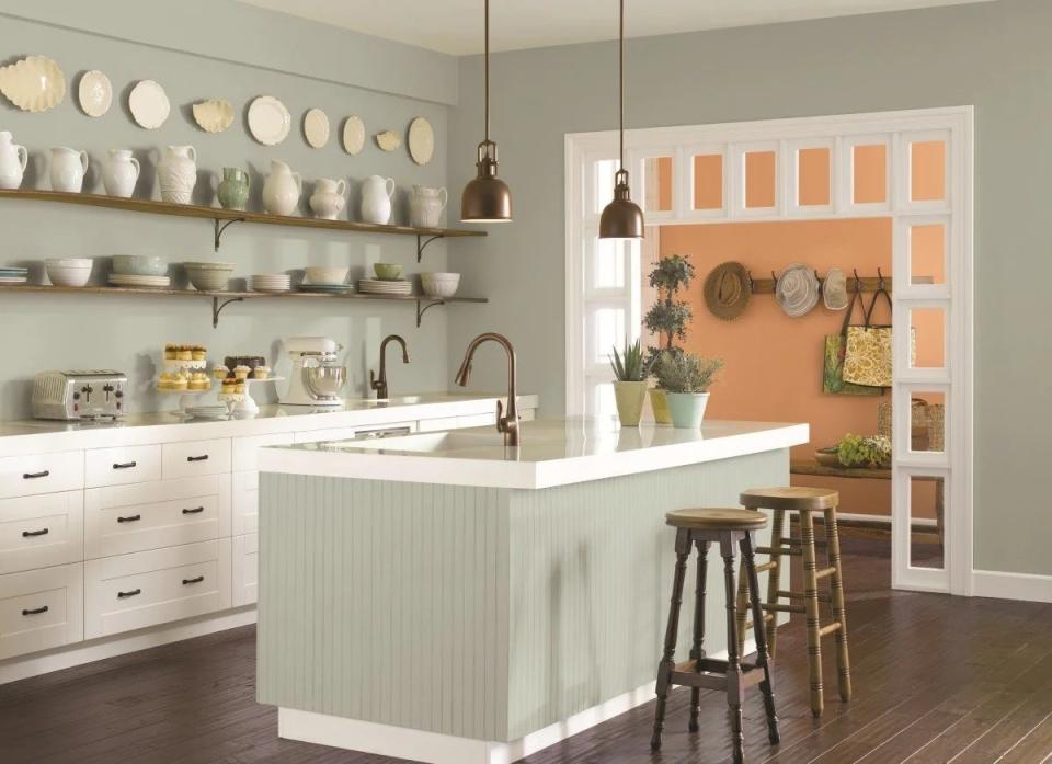 Kitchen with greenish gray colored island painted in Oyster Bay by Sherwin-Williams.