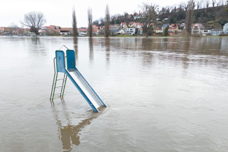 A slide stands in the high water of the Elbe. The flood situation in Saxony remains tense, especially on the Elbe. Sebastian Kahnert/dpa