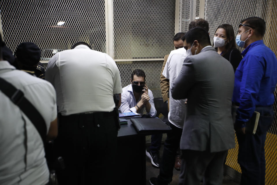 The son of former Panamenian President Ricardo Martinelli, Ricardo Martnelli Linares, centerspeask on his mibole phone before a hearing at the judicial court building in Guatemala City, Monday, July 6, 2020. Guatemalan police detained the Martinelli brothers Ricardo and Luis Enrique Martinelli Linares on an Interpol warrant for money laundering, as they attempted to board a private plane out of the country. (AP Photo/Moises Castillo)