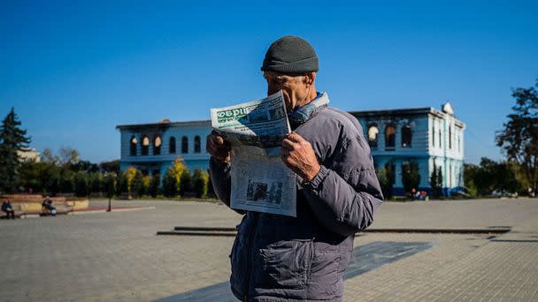 PHOTO: This photo taken on Oct. 18, 2022, shows a local resident reading a newspaper while he waits to receive a food package on the central square in the town of Izyum, amid Russia's invasion of Ukraine. (Dimitar Dilkoff/AFP via Getty Images)