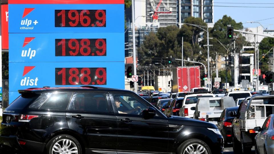 Petrol station showing fuel prices and car.