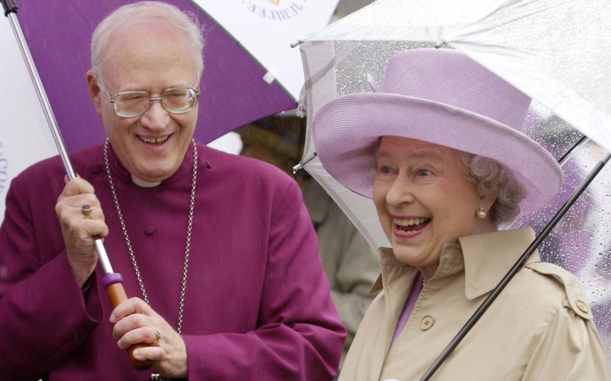 Queen Elizabeth II cheerfully braves heavy rain with the then Archbishop of Canterbury - PA