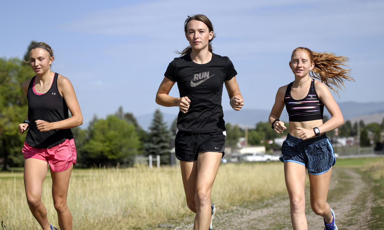 University of Montana cross country runner Juniper Eastwood, center, warming up with her teammates at Campbell Park in Missoula, Mont. on Aug. 15, 2019.  (Rachel Leathe / Bozeman Daily Chronicle via AP file)