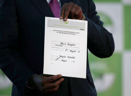 Incumbent President Uhuru Kenyatta holds the certificate of his president-elect of the Republic of Kenya after he was announced winner of the presidential election at the IEBC National Tallying centre at the Bomas of Kenya, in Nairobi, Kenya August 11, 2017. REUTERS/Thomas Mukoya