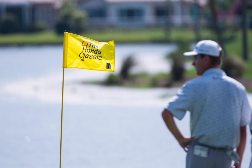 The Honda Classic logo is seen on a pin on the 18th hole as Ryan Gerard observes the action on the green during the second round of the Honda Classic at PGA National Resort & Spa on Friday, February 24, 2023, in Palm Beach Gardens, FL.