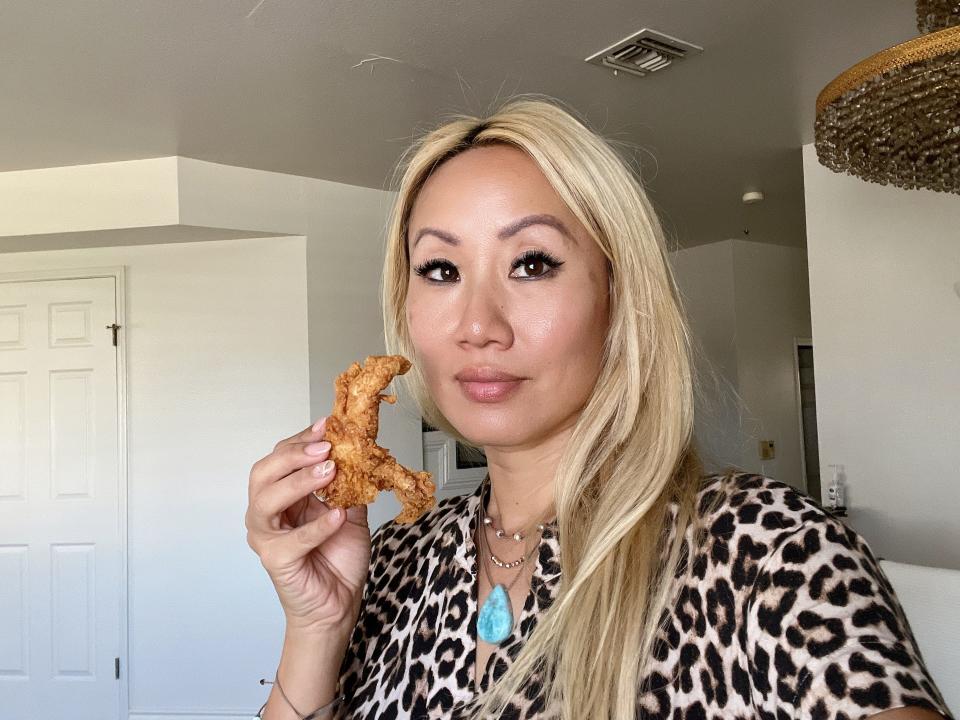 The writer holds a chicken finger from Raising Cane's