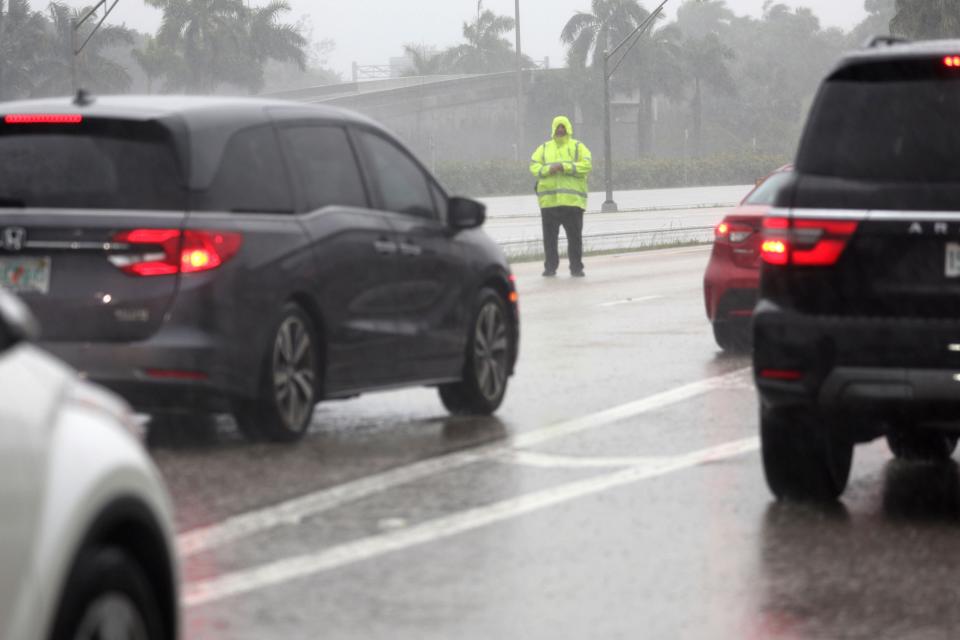 A Broward Sheriff's Office Deputy directs traffic away from the Fort Lauderdale-Hollywood International Airport, which has closed to all flights and traffic on Wednesday, April 12, 2023, in Fort Lauderdale, Fla. (Carline Jean/South Florida Sun-Sentinel via AP)