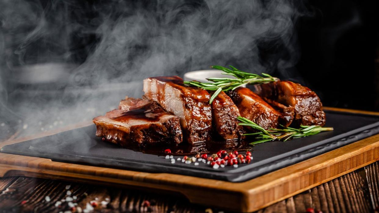 A nice steak dinner that's been placed on a wooden cutting board.