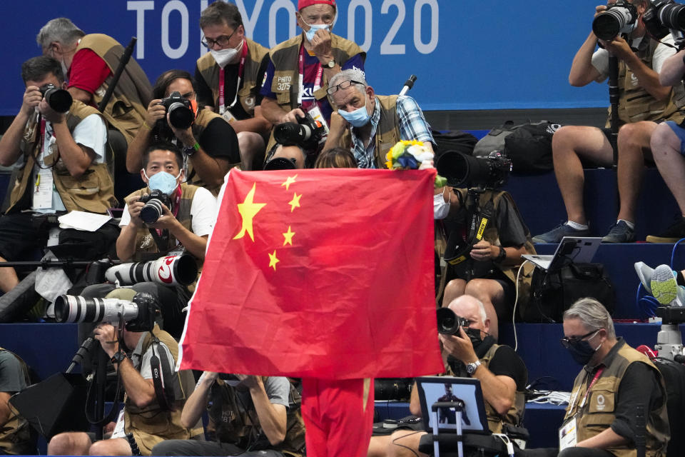 FILE - A Chinese flag is unfurled on the podium of a swimming event final at the 2020 Summer Olympics, on July 29, 2021, in Tokyo, Japan. An Australian newspaper said Saturday, April 20, 2024, 23 Chinese swimmers were cleared to compete at the Tokyo Olympics despite testing positive to doping because world governing bodies agreed with Chinese authorities and ruled that the tests had been contaminated.(AP Photo/Charlie Riedel, File)