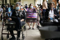 FILE - In this Jan. 12, 2021, file photo, Resident Sabeth Ramirez, 80, center, waits in line with others for the Pfizer-BioNTech COVID-19 vaccine at the The Palace assisted living facility in Coral Gables, Fla. Governors and health officials have been reluctant to sign on to a Biden administration plan to open 100 federally supported vaccination sites by the end of February. With vaccine supplies running tight, they want assurances that the doses will come from a separate federal supply and not their own. (AP Photo/Lynne Sladky, File)