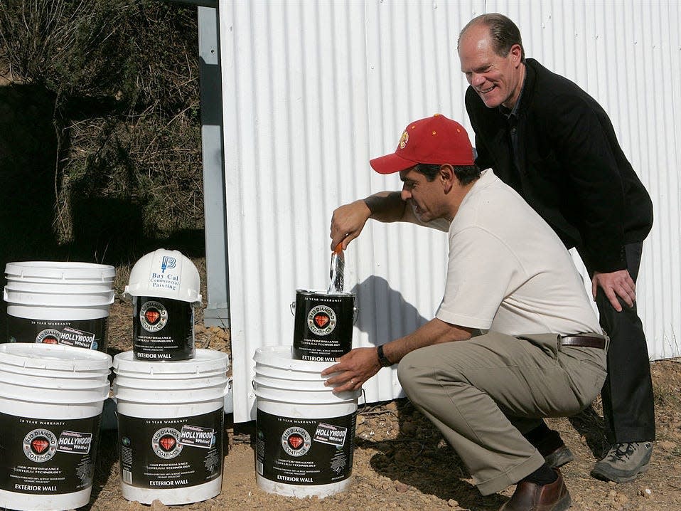 Two men paint the Hollywood sign with white paint