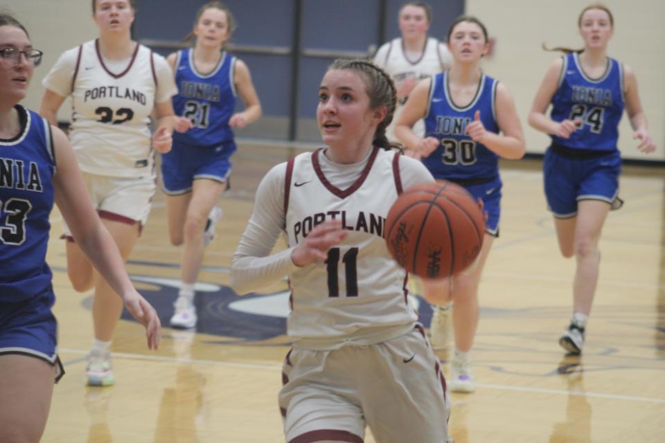 Portland freshman guard Lilly Thelen (No. 11) dribbles past the Ionia defense during a MHSAA Division 2 district championship game Friday, March 3, at Lakewood High School. Portland won the game, 45-26, to win its fourth consecutive district title.