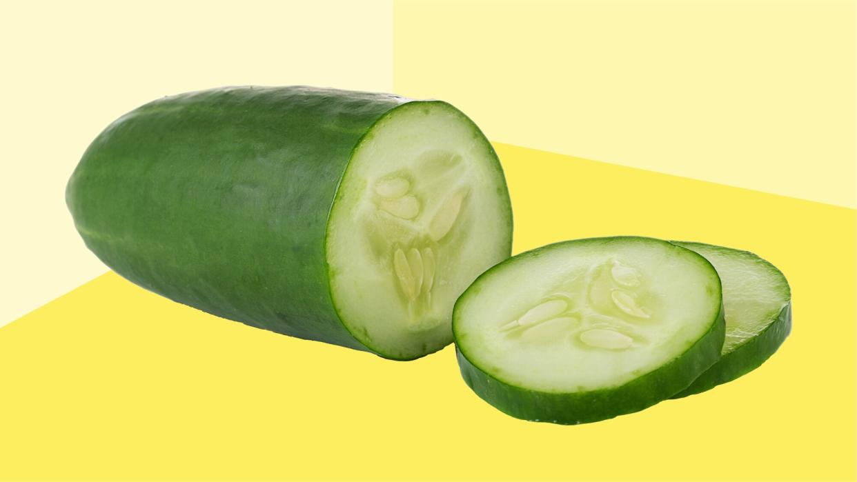 A silo of a sliced cucumber on a yellow background