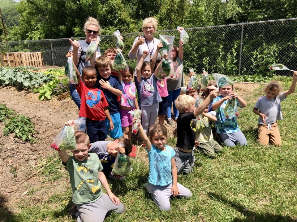 Hot Springs Elementary School students hold up the radishes they harvested, which are bagged and ready to bring home to their families.