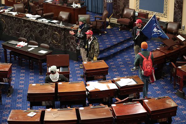 WASHINGTON, DC - JANUARY 06: Protesters enter the Senate Chamber on January 06, 2021 in Washington, DC. Congress held a joint session today to ratify President-elect Joe Biden's 306-232 Electoral College win over President Donald Trump. Pro-Trump protesters have entered the U.S. Capitol building after mass demonstrations in the nation's capital. (Photo by Win McNamee/Getty Images)
