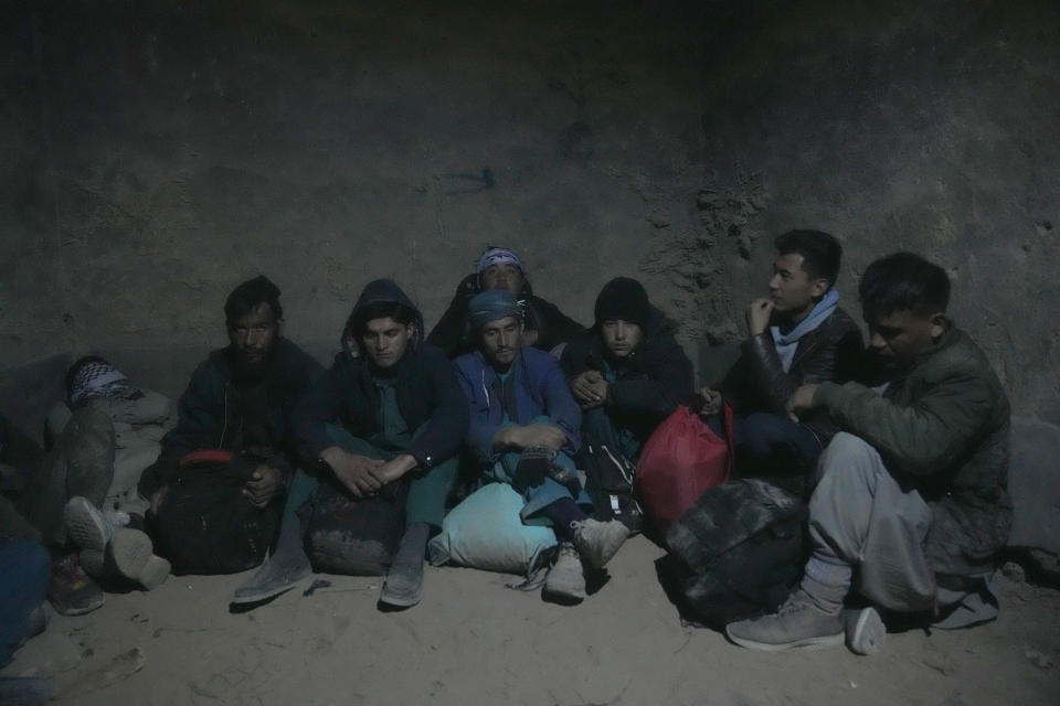 Young Shiite Afghan immigrants wait for midnight in ruins in the desert around the city of Zaranj, Afghanistan, near the the Iran-Afghanistan border wall, to try to cross over the Iranian border wall into Iran, Monday, Dec. 25, 2023. Mostly the young men, from 12 to their 20s, use this route, planning to work in Iran and send money home to their families. Many are caught by Iranian border guards and sent back. (AP Photo/Ebrahim Noroozi)