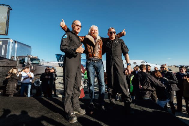 Virgin Galactic founder Richard Branson, center, celebrates this week’s successful test flight of VSS Unity with test pilots Rick “CJ” Sturckow at left and Mark “Forger” Stucky at right. Branson says he’ll be Unity’s first commercial passenger. (Virgin Galactic / Quasar Media Photo)