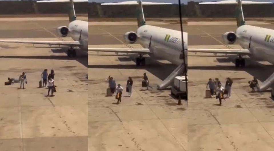 委內瑞拉雷射航空起飛時機身突冒濃煙，乘客被緊急疏散時，竟拖行李箱一起逃生。（翻攝X@Enrique77W）
