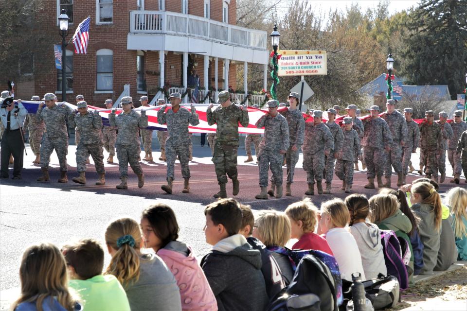 Local elementary school students watch a passing procession of JROTC students from Aztec High School on Nov. 11, 2019 during the Veterans Day Parade in Aztec.