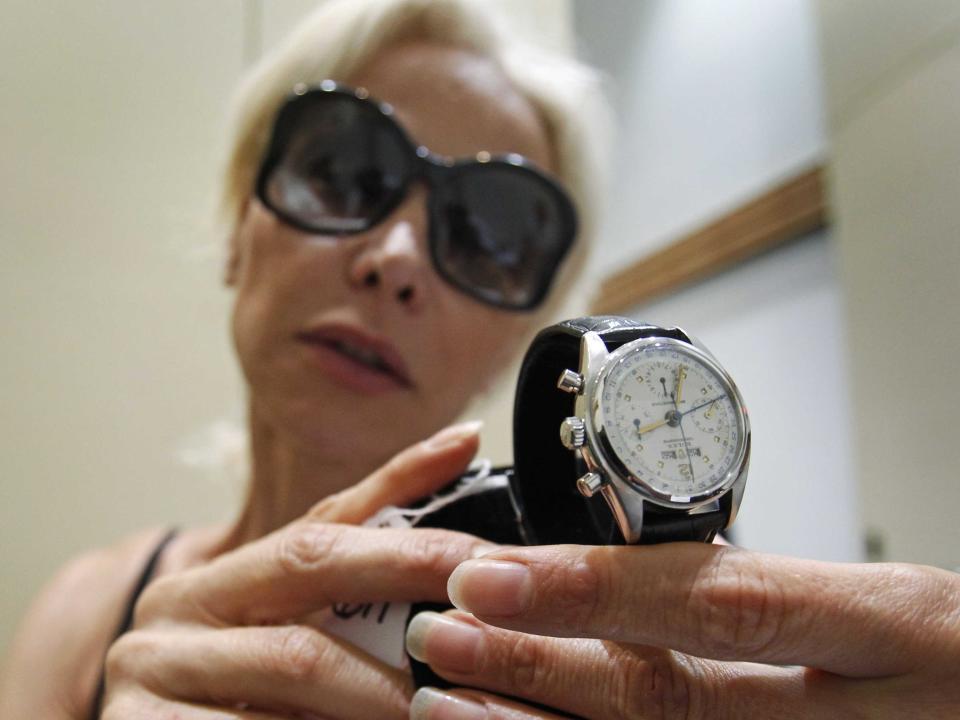 woman holding a Rolex watch