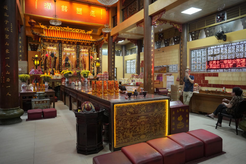 A man waits inside the Kuang Kong Buddhist Temple in Binondo district, said to be the oldest Chinatown in the world, in Manila, Philippines on Tuesday Feb. 6, 2024, Crowds are flocking to Manila's Chinatown to usher in the Year of the Wood Dragon and experience lively traditional dances on lantern-lit streets with food, lucky charms and prayers for good fortune. (AP Photo/Aaron Favila)